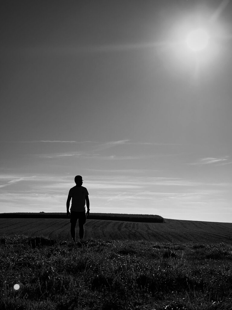 Un homme en contre-jour regardant au loin.