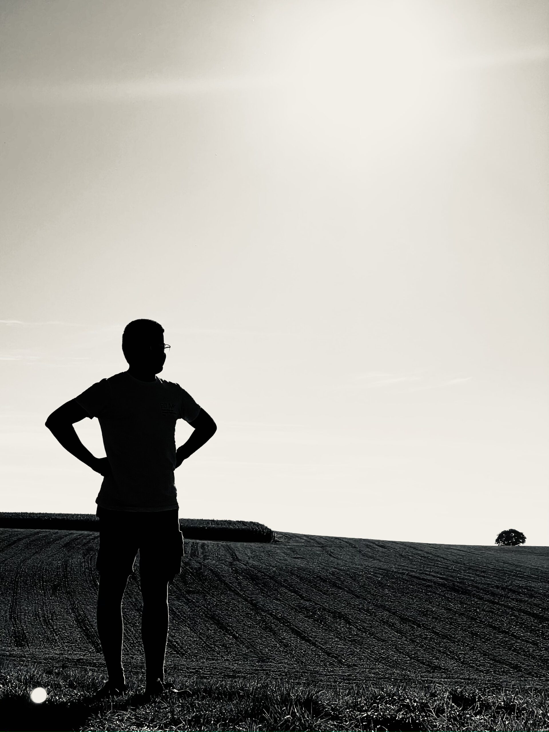 Un homme en contre-jour regardant au loin.